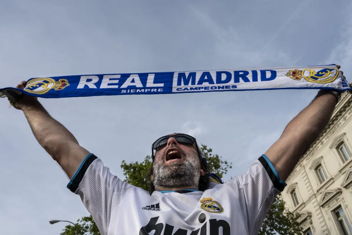 A Spanish football club Real Madrid fan celebrates the 2021/