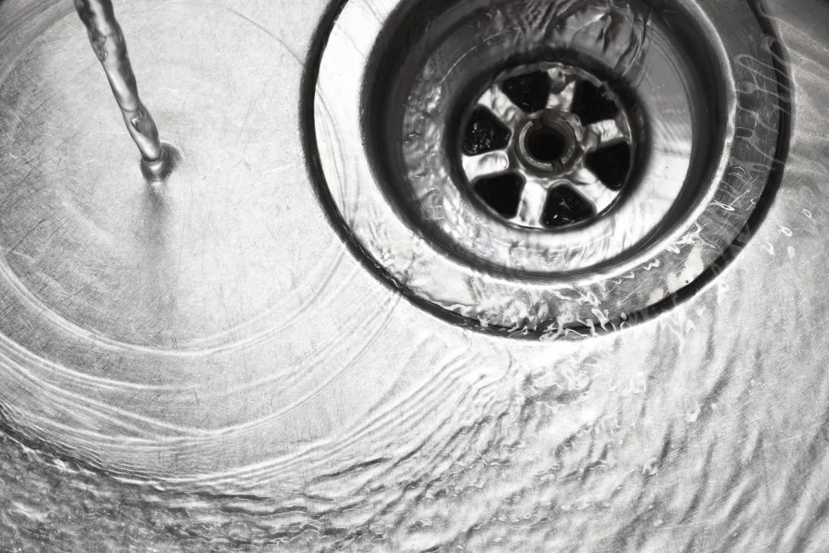 Stainless,Steel,Sink,Plug,Hole,Close,Up,With,Water