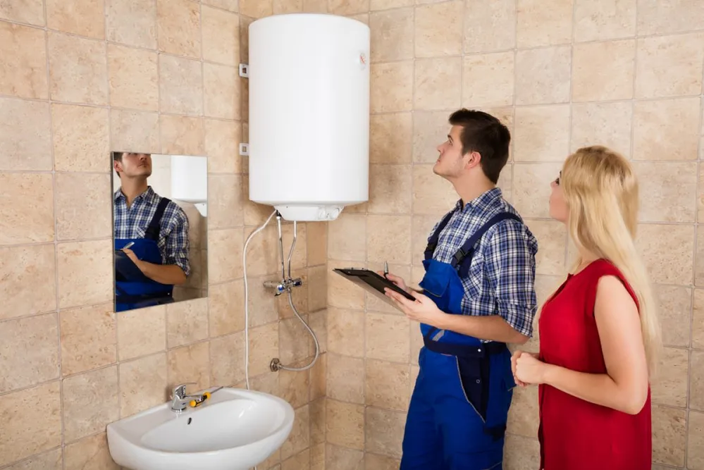 Woman,Looking,At,Young,Male,Plumber,Holding,Clipboard,Looking,At