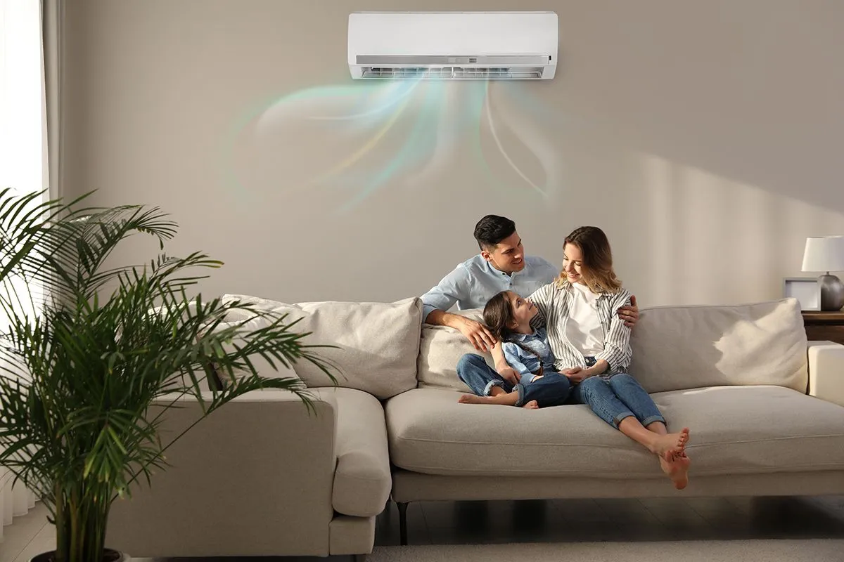 Happy,Family,Resting,Under,Air,Conditioner,On,Beige,Wall,At