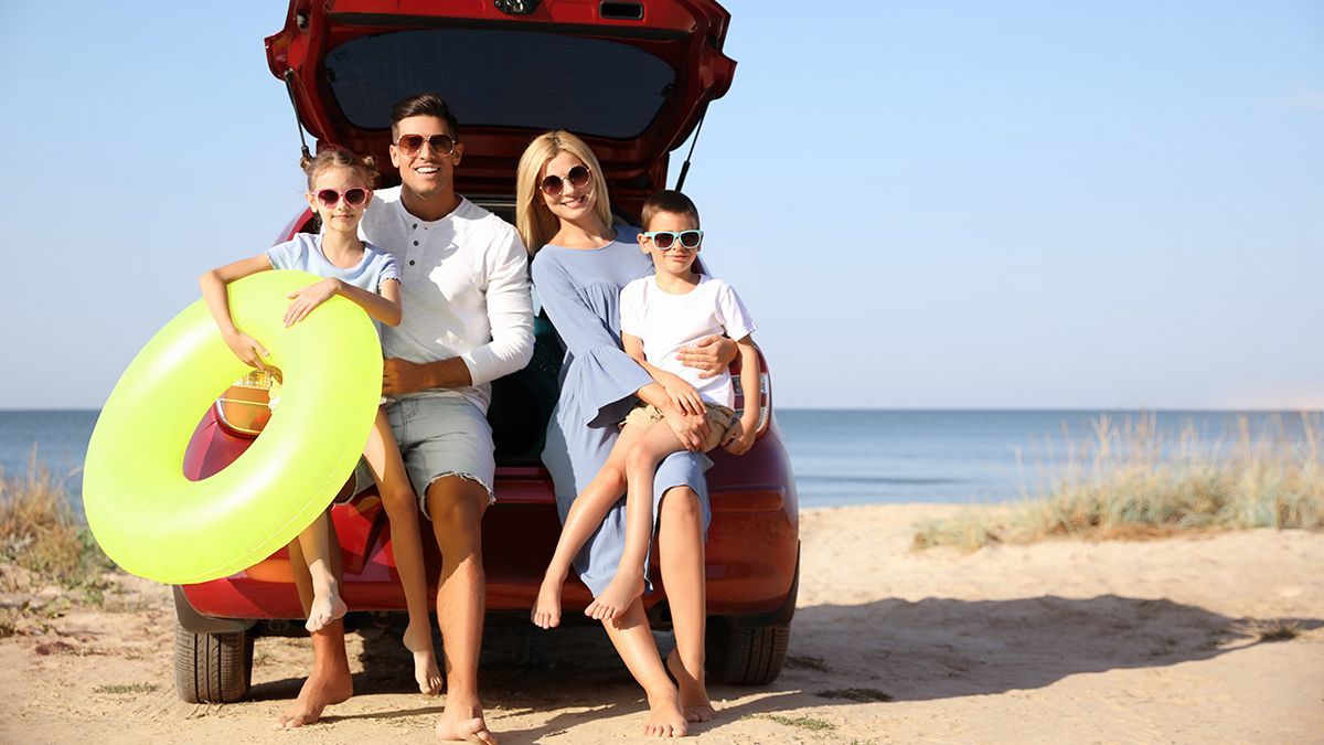 Happy,Family,With,Inflatable,Ring,Near,Car,At,Beach,On