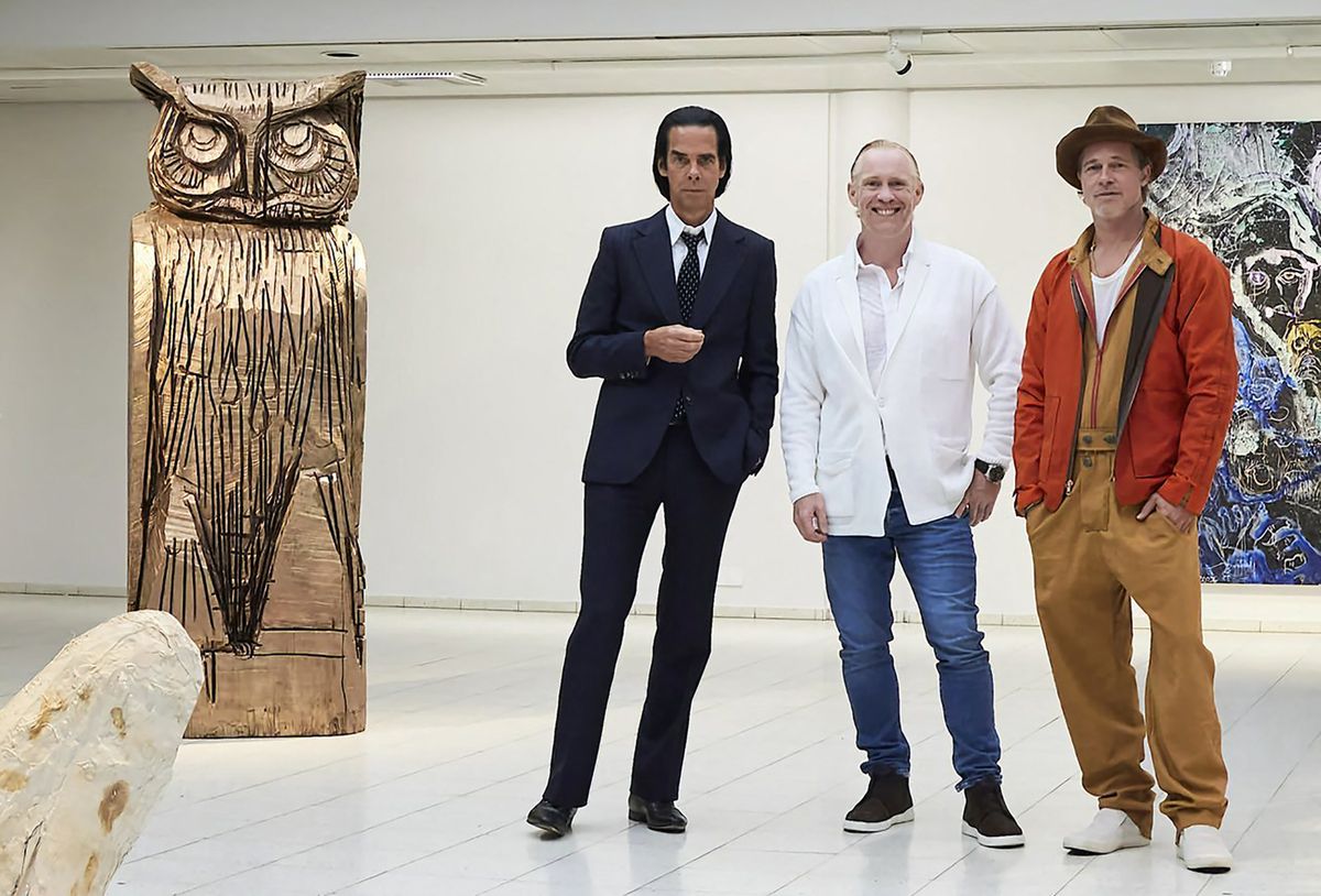 This handout photo taken on September 17, 2022 and received on September 19, 2022 shows British artist Thomas Houseago (C) posing with US actor Brad Pitt (R) and Australian  musician Nick Cave prior to the opening of the exhibition 'Thomas Houseago - WE with Nick Cave and Brad Bitt' at The Sara Hilden Art Museum in Tampere, Finland. - For the exhibition, British-born artist Thomas Houseago displays new paintings and sculptures alongside a ceramic series by Nick Cave and sculptures by Brad Pitt, according to the museum. For Cave and Pitt it is the first time ever that they exhibit their works of art, which were created during the course of an ongoing dialogue with Houseago. (Photo by Jussi Koivunen / various sources / AFP) / - Finland OUT / RESTRICTED TO EDITORIAL USE - MANDATORY CREDIT "AFP PHOTO /  JUSSI KOIVUNEN / SARA HILDEN ART MUSEUM" - NO MARKETING - NO ADVERTISING CAMPAIGNS - DISTRIBUTED AS A SERVICE TO CLIENTS