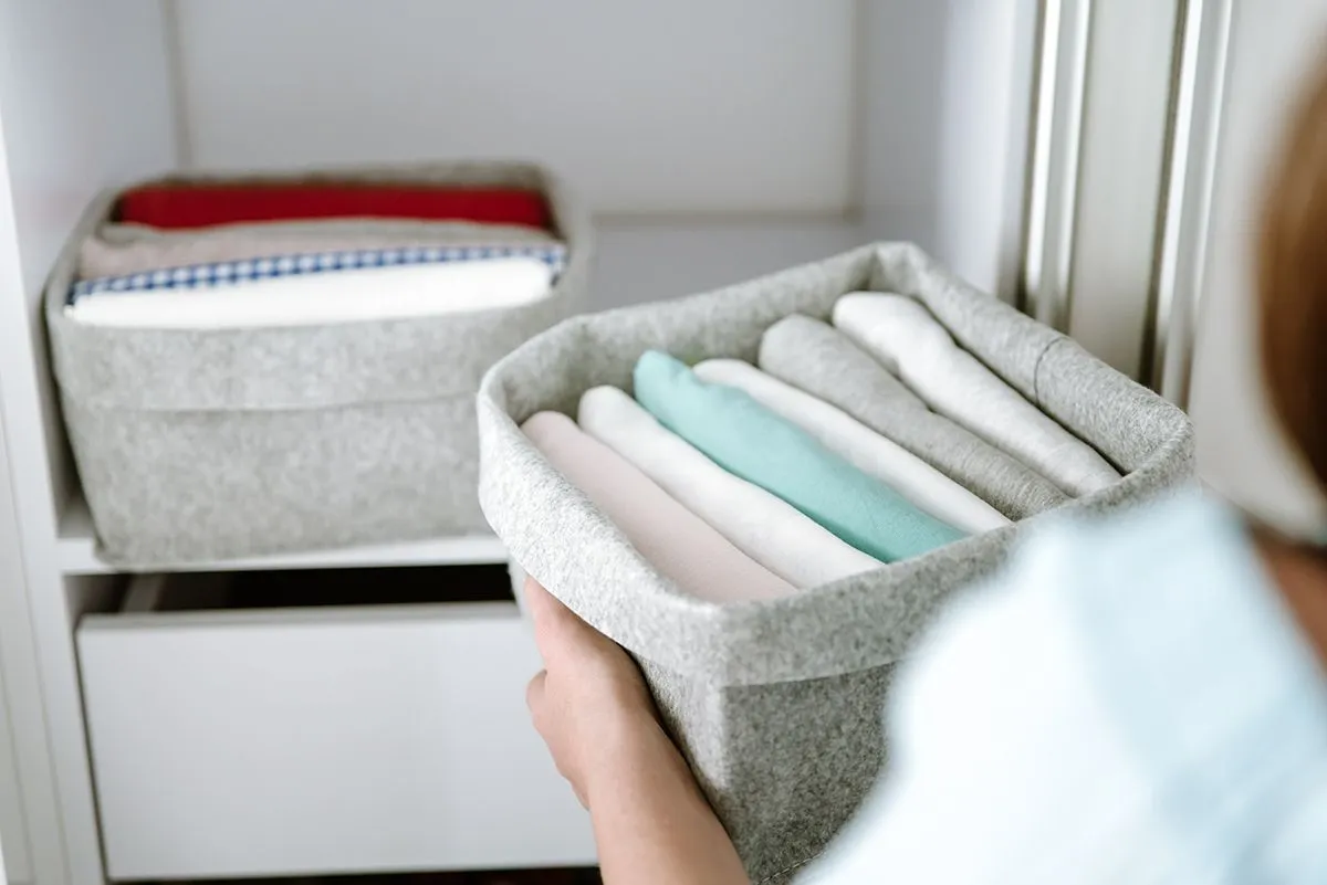Woman,Organizing,Clothes,In,Wardrobe,,Putting,Shirts,In,Boxes,,Baskets