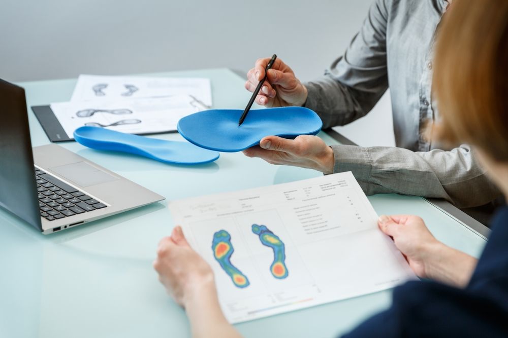 Doctor,Consulting,Patient,On,Custom,Orthotic,Insoles,In,A,Clinic
