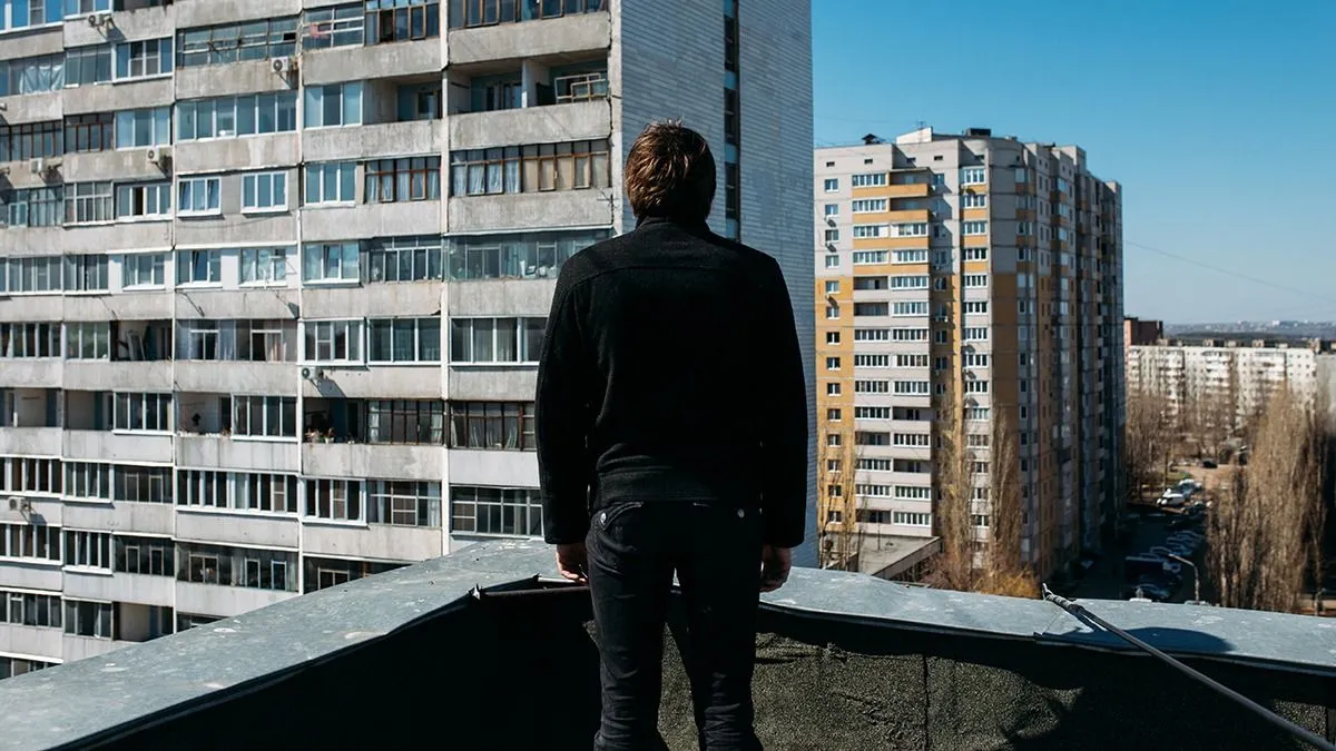 Young,Teenager,Stands,On,The,Roof,Of,A,House,On