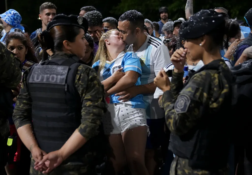 Buenos Aires, 2022. december 20.
A katari labdarúgó-világbajnokságról győztesen hazatérő argentin válogatott köszöntésére készülő szurkolók csókolóznak Buenos Airesben 2022. december 20-án.
MTI/AP/Matilde Campodonico