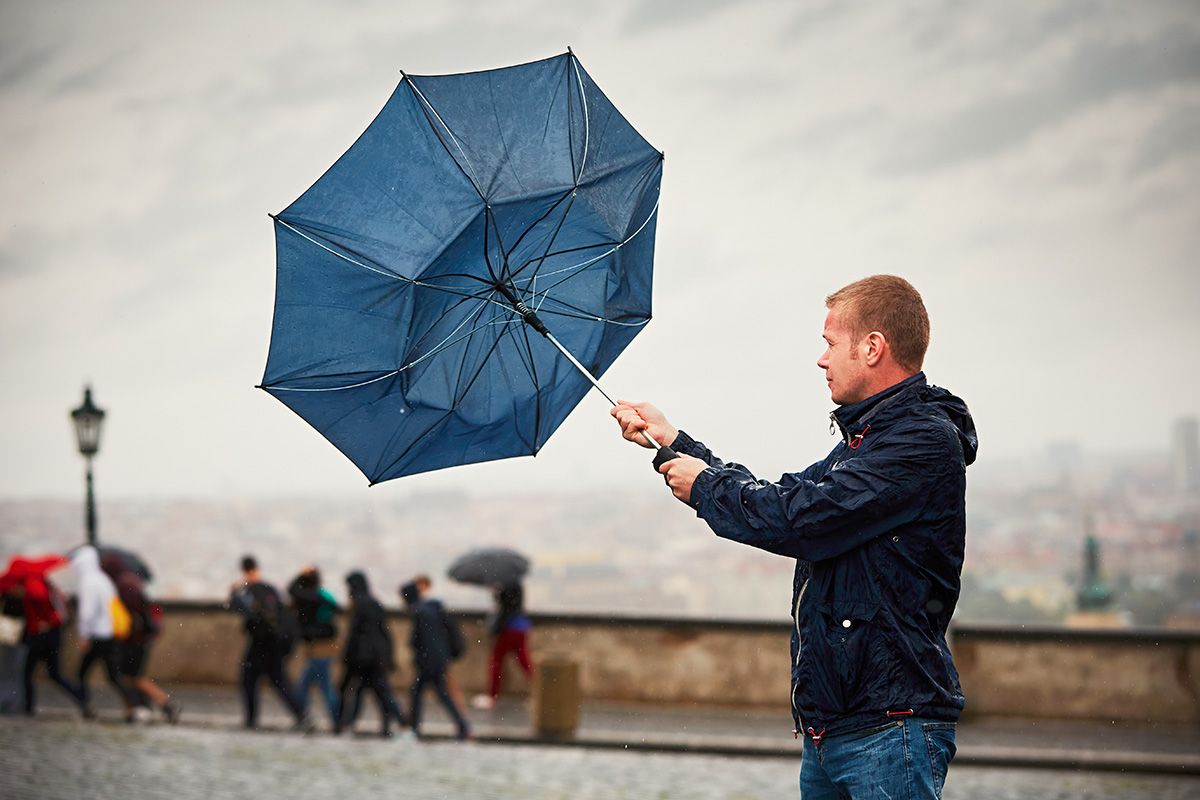 Rain,In,The,City.,Young,Man,Is,Holding,Blue,Umbrella