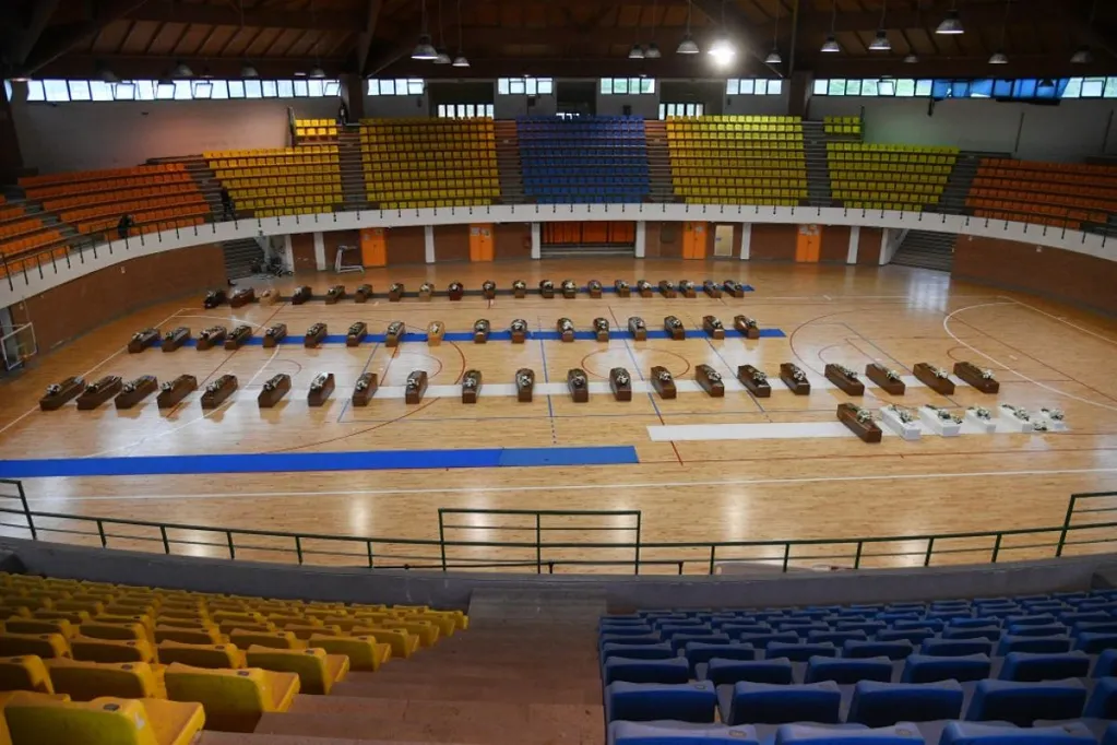 A hajószerencsétlenség áldozatainak koporsói egy crotonei sportcsarnokban