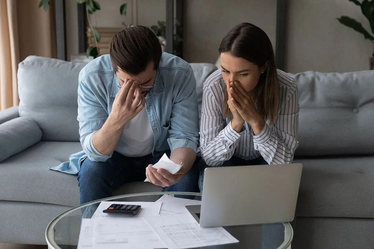 Confused,Upset,Millennial,Married,Couple,Sit,On,Couch,Read,Financial