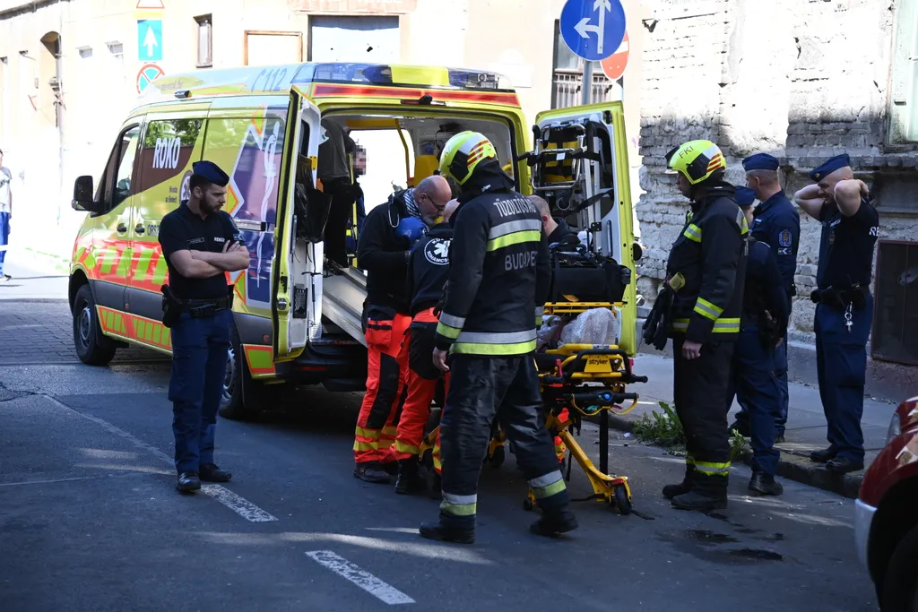 Budapest, 2023. május 1.
Mentők egy sérültet tesznek a mentőautóba a főváros VIII. kerületében, egy Bérkocsis utcai ház előtt, ahol az épületben gázrobbanás történt 2023. május 1-jén. Az egyemeletes társasházban a födém beszakadt, a falak megrogytak, ablakok, ajtók szakadtak ki, tűz azonban nem keletkezett. Egy embert a romok alól emeltek ki a tűzoltók, majd a mentők kórházba vitték.
MTI/Mihádák Zoltán