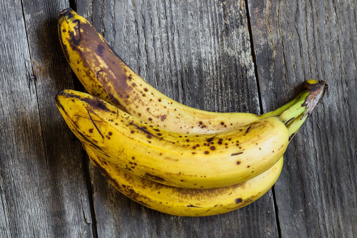 Three,Ripe,Bananas,Over,A,Wooden,Background,-,Top,View