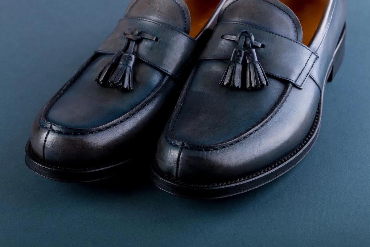 Blue loafer shoes on blue background.