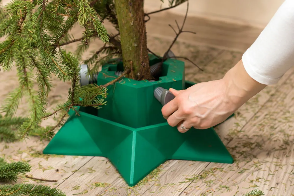 Female,Hands,Unscrew,The,Base,Under,The,Christmas,Tree.,Cleaning