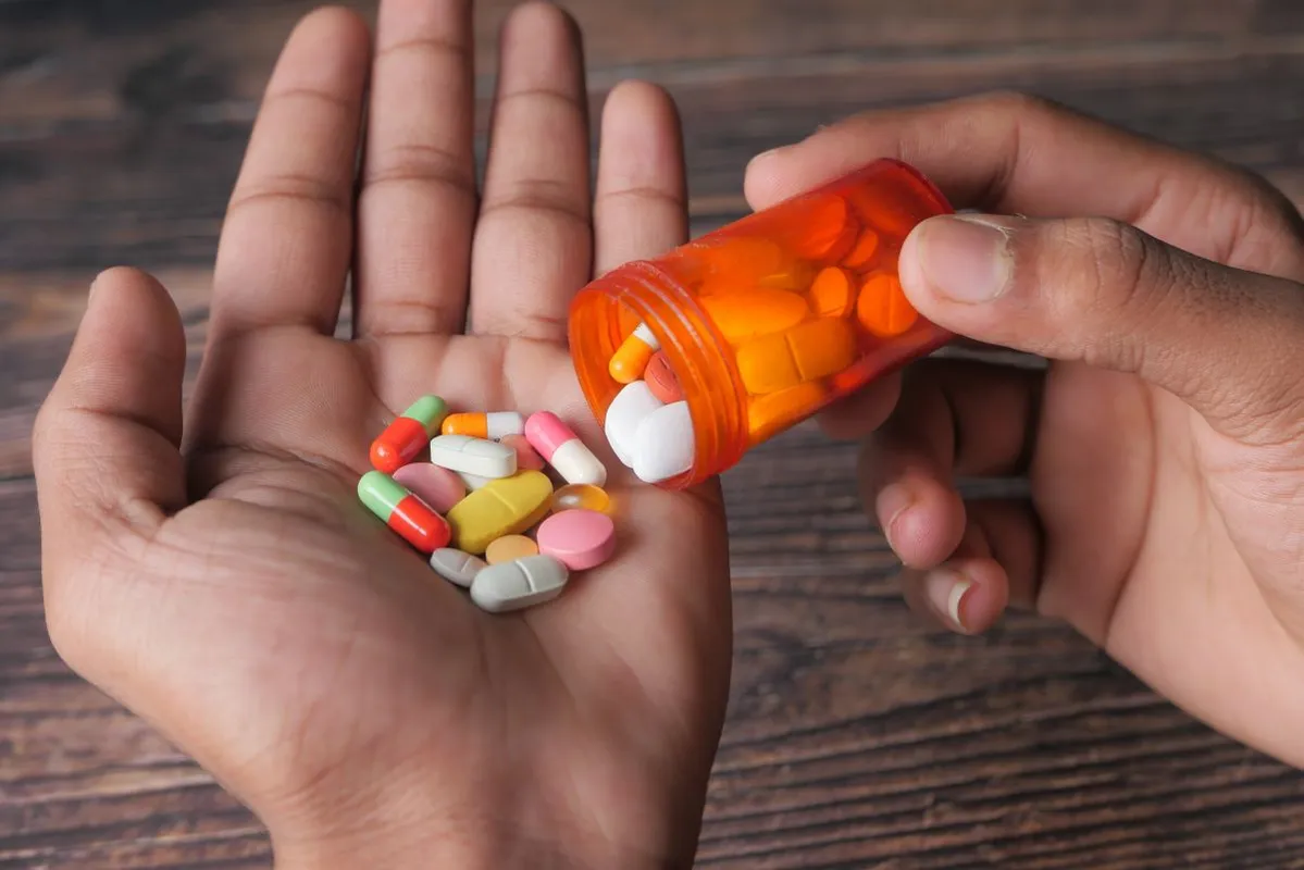 Man's,Hand,With,Medicine,Spilled,Out,Of,The,Pill,Container