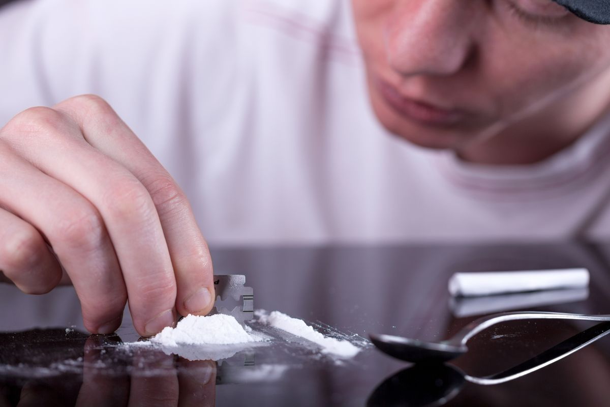 Closeup,Of,A,Man's,Hand,Cutting,Cocaine,On,A,Glass