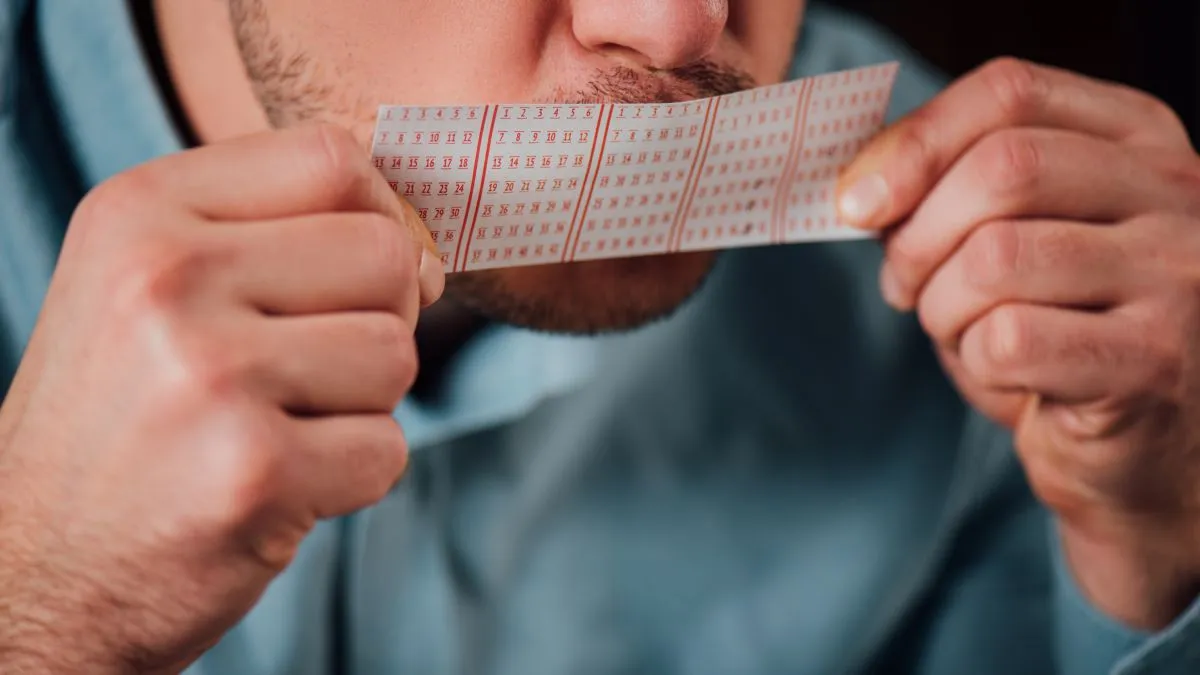 Cropped,View,Of,Man,Kissing,Lottery,Ticket,For,Luck