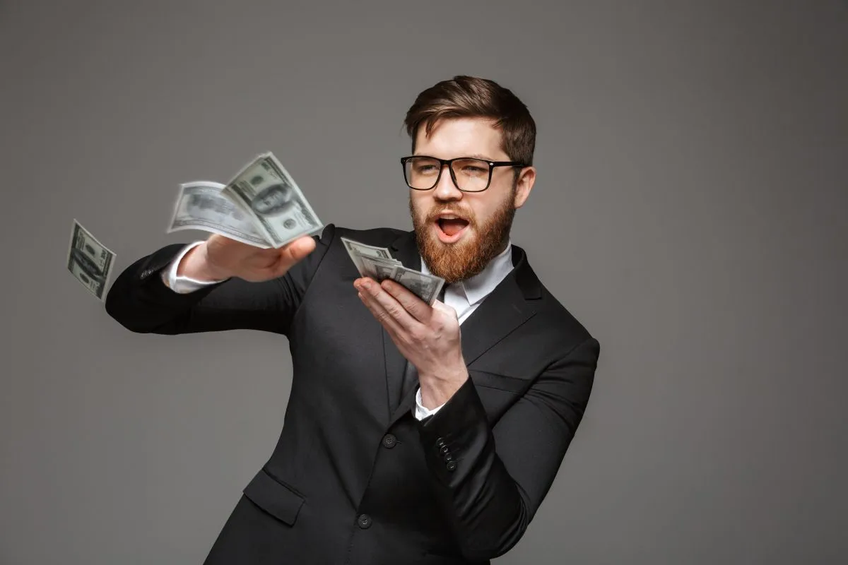 Portrait,Of,A,Happy,Young,Businessman,Throwing,Out,Money,Banknotes