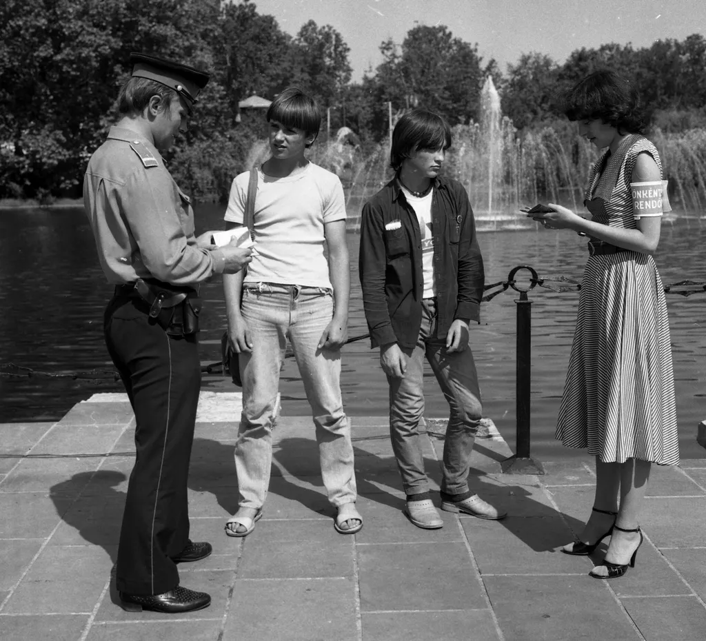 Egy rendőr, valamint egy önkéntes rendőr hölgy igazoltat fiatalokat a Városligeti-tónál 1982-ben