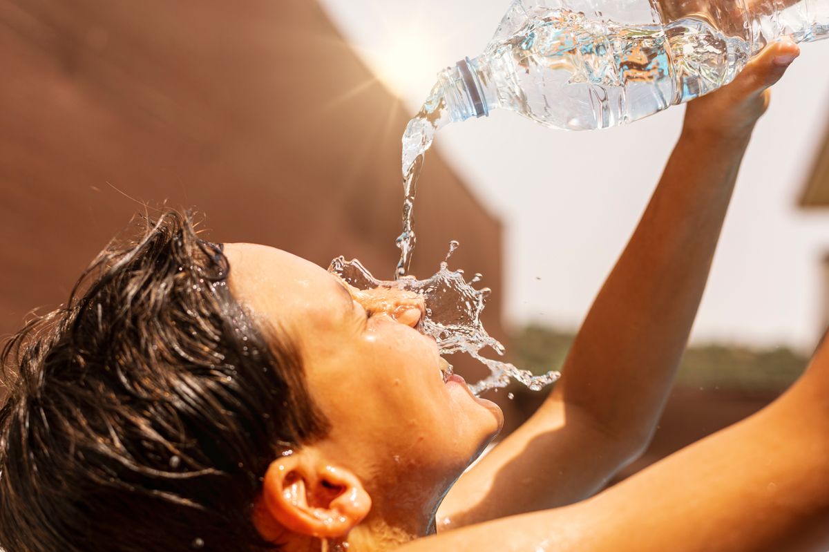 Young,Man,Throwing,Water,From,The,Bottle,Over,His,Head