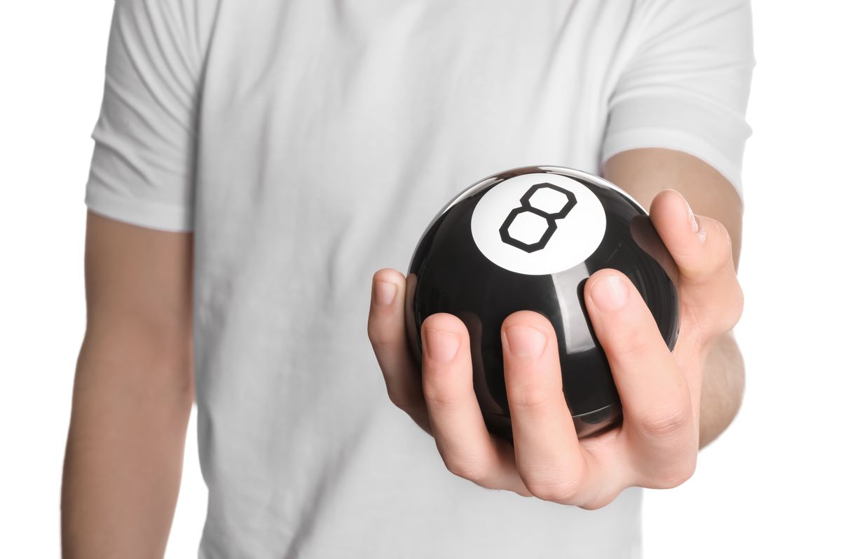 Man,Holding,Magic,Eight,Ball,On,White,Background,,Closeup