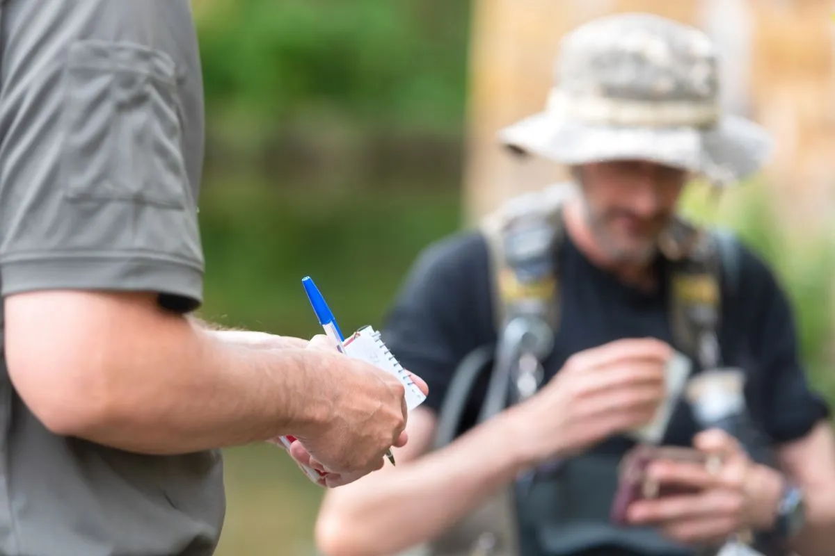 Police,Officer,Or,Ranger,Checking,Fisherman,License,In,River.,Fishing