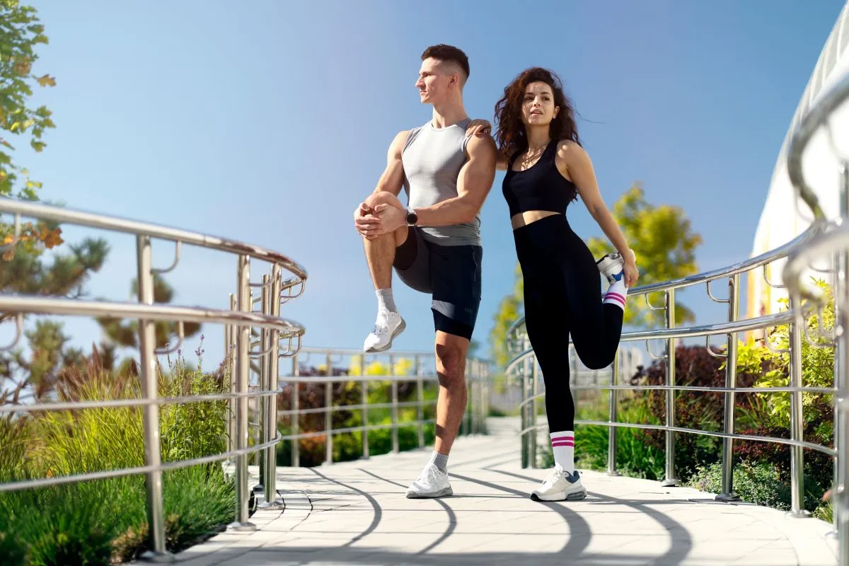 Active,Sporty,Couple,,Man,And,Woman,Stretching,Legs,,Preparing,For