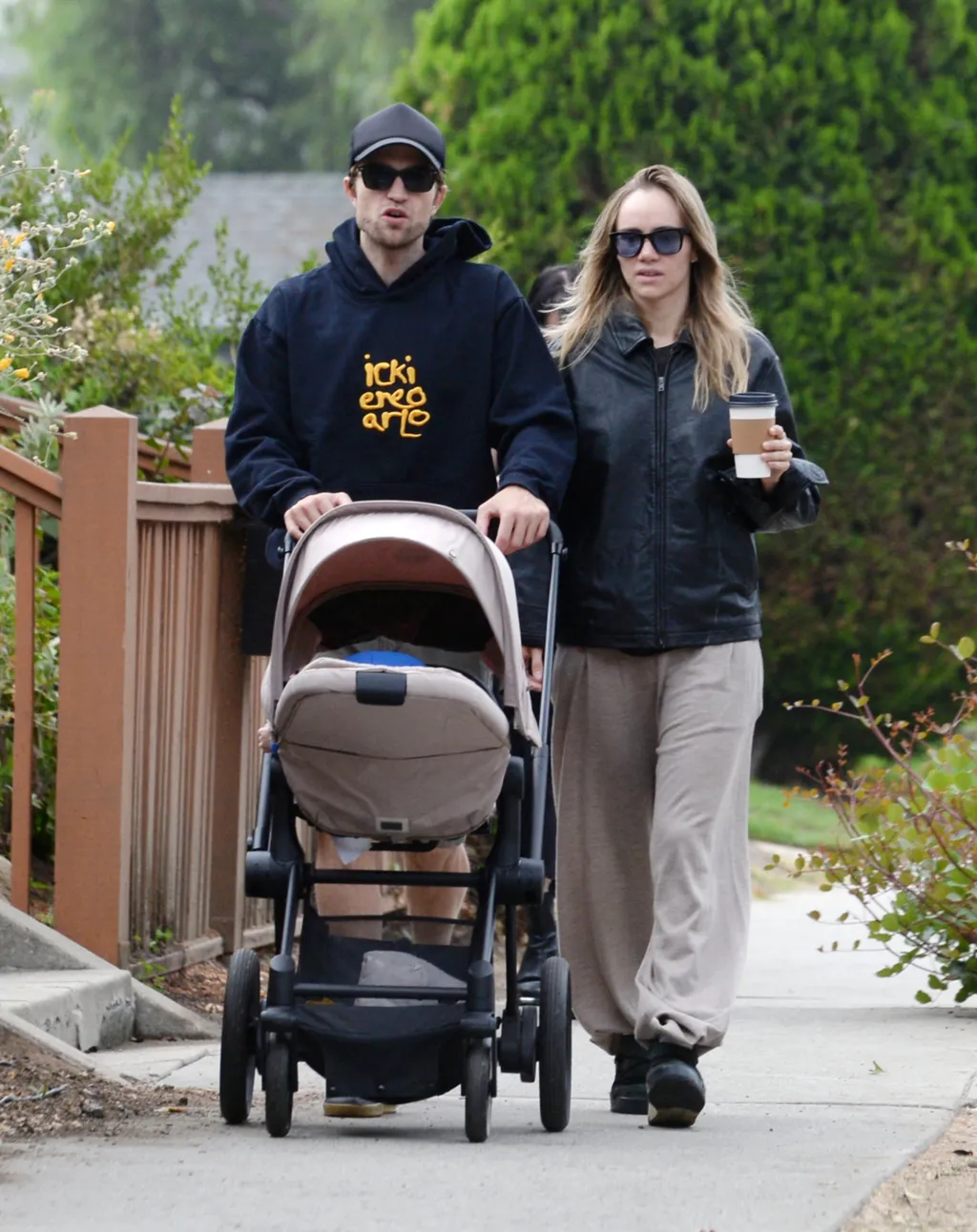 09/24/2024 EXCLUSIVE: Robert Pattinson and Suki Waterhouse out as a family in Los Angeles. The Batman actor flashed a smile while pushing a pram while on a coffee run. Suki was dressed casual in a leather jacket, brown joggers, and black boots.

**VIDEO