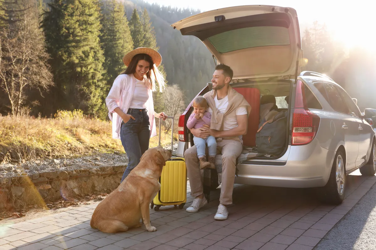 Parents,,Their,Daughter,And,Dog,Near,Car,Outdoors.,Family,Traveling