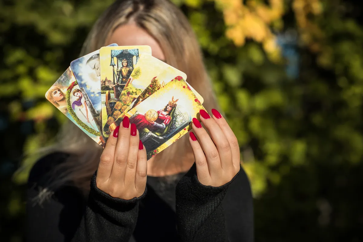 Szőke nő tarot-paklival a kezében