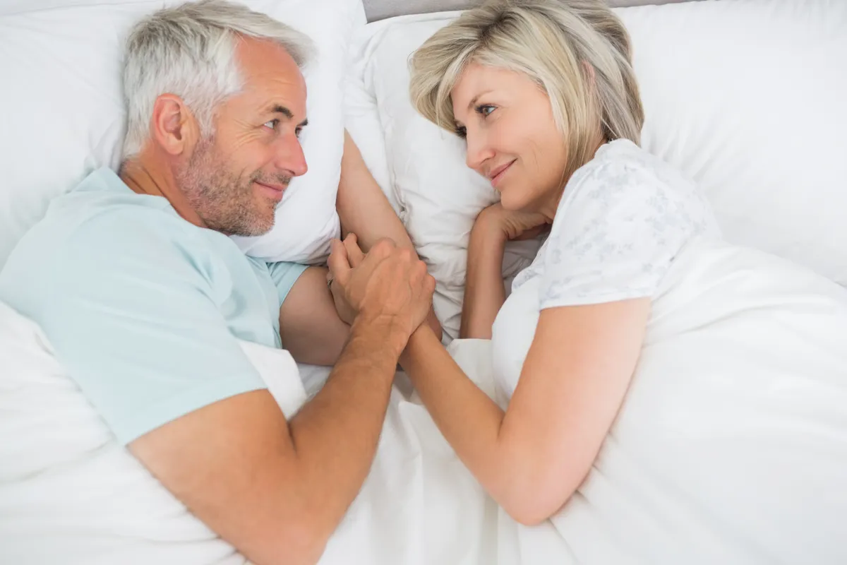 Klimaxoló nő fekszik az ágyban a párjával