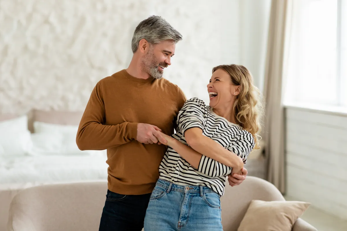 Happy,Marriage.,Cheerful,Middle,Aged,Couple,Dancing,In,Modern,Bedroom