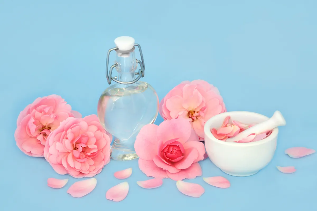 Rose,Flower,Perfume,In,Heart,Shaped,Bottle,With,Flowers,And