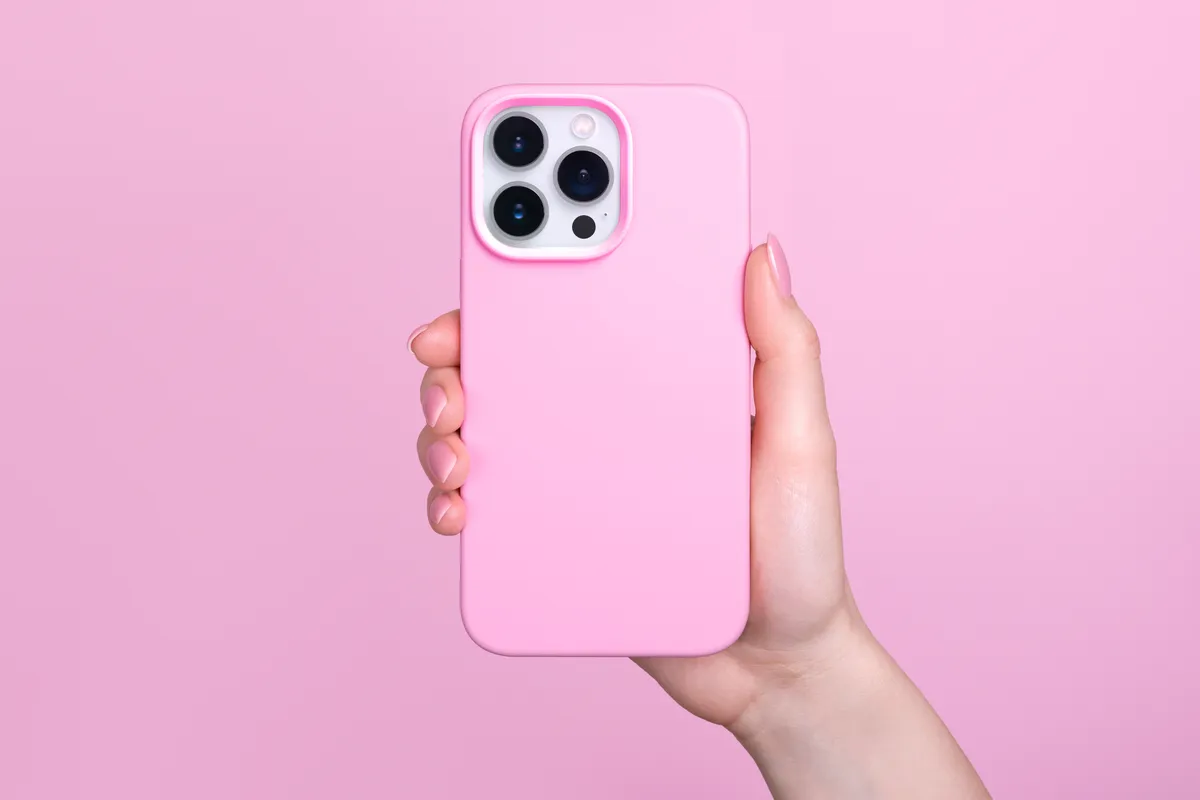 telefon, iphone, rózsaszín szilikon tok, fehér okostelefon, női kéz, rózsaszín háttér
