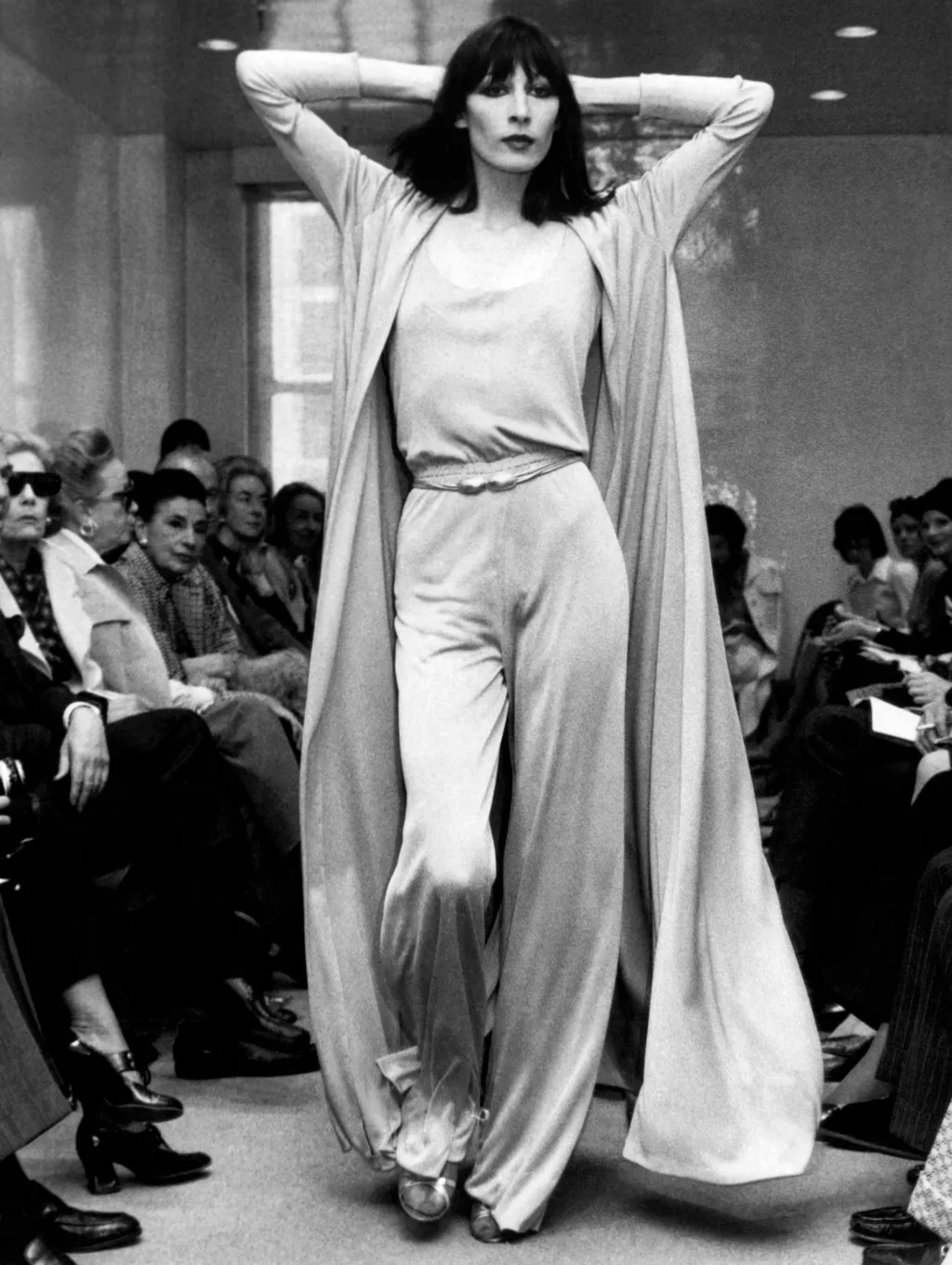 New York, New York: May 23, 1972
Angelica Huston models a Halston Originals jersey evening pants ensemble with a matching full coat.
