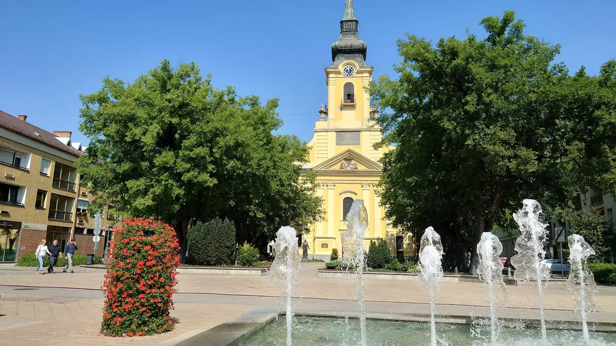 Gyula, templom, szökőkút, virágos közterület
