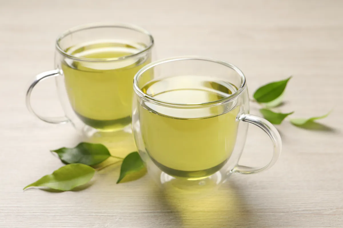 Refreshing,Green,Tea,In,Cups,And,Leaves,On,Wooden,Table,
