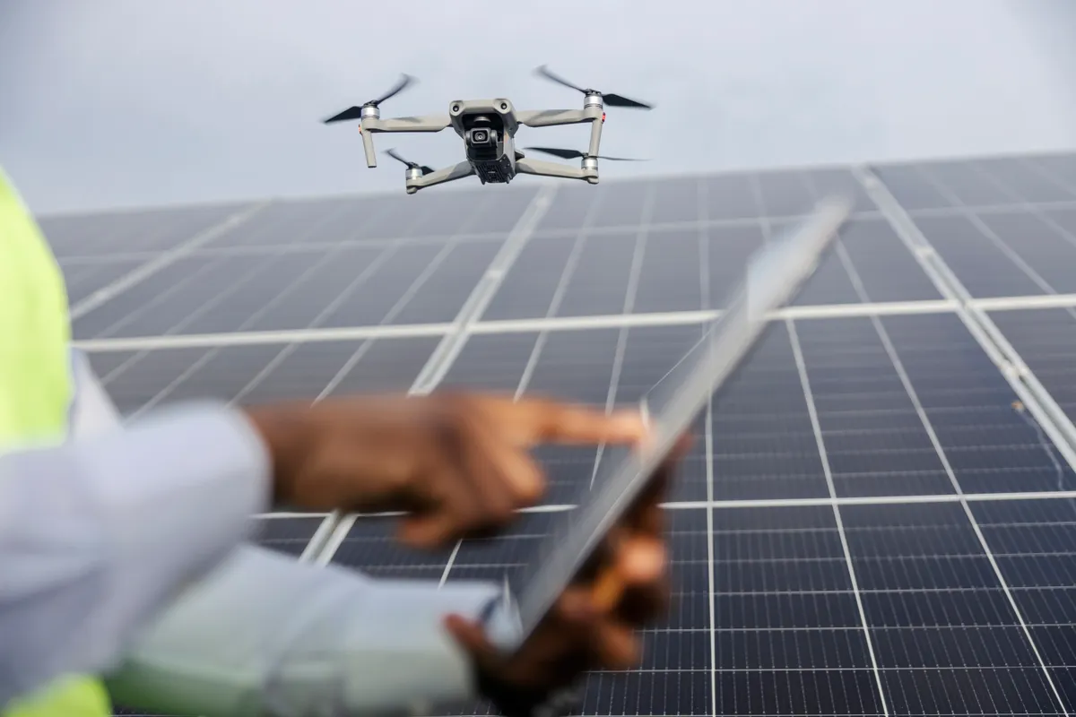 Selective,Focus,On,Flying,Drone,At,Solar,Farm,With,Multicultural