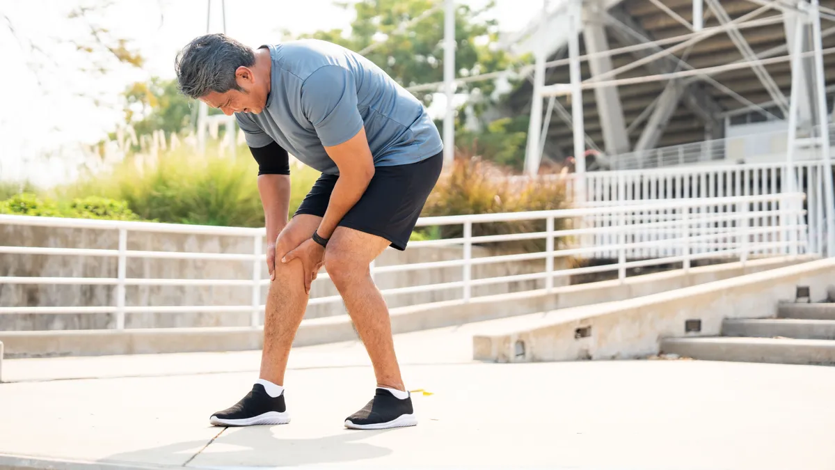 Mature,Man,Tired,And,Leg,Pain,During,Jogging,At,Sport