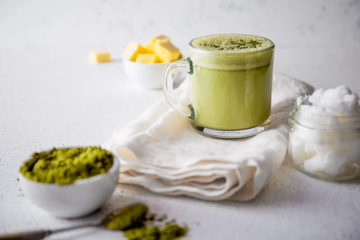 Egy csésze krémes matcha latte egy fehér konyharuhán