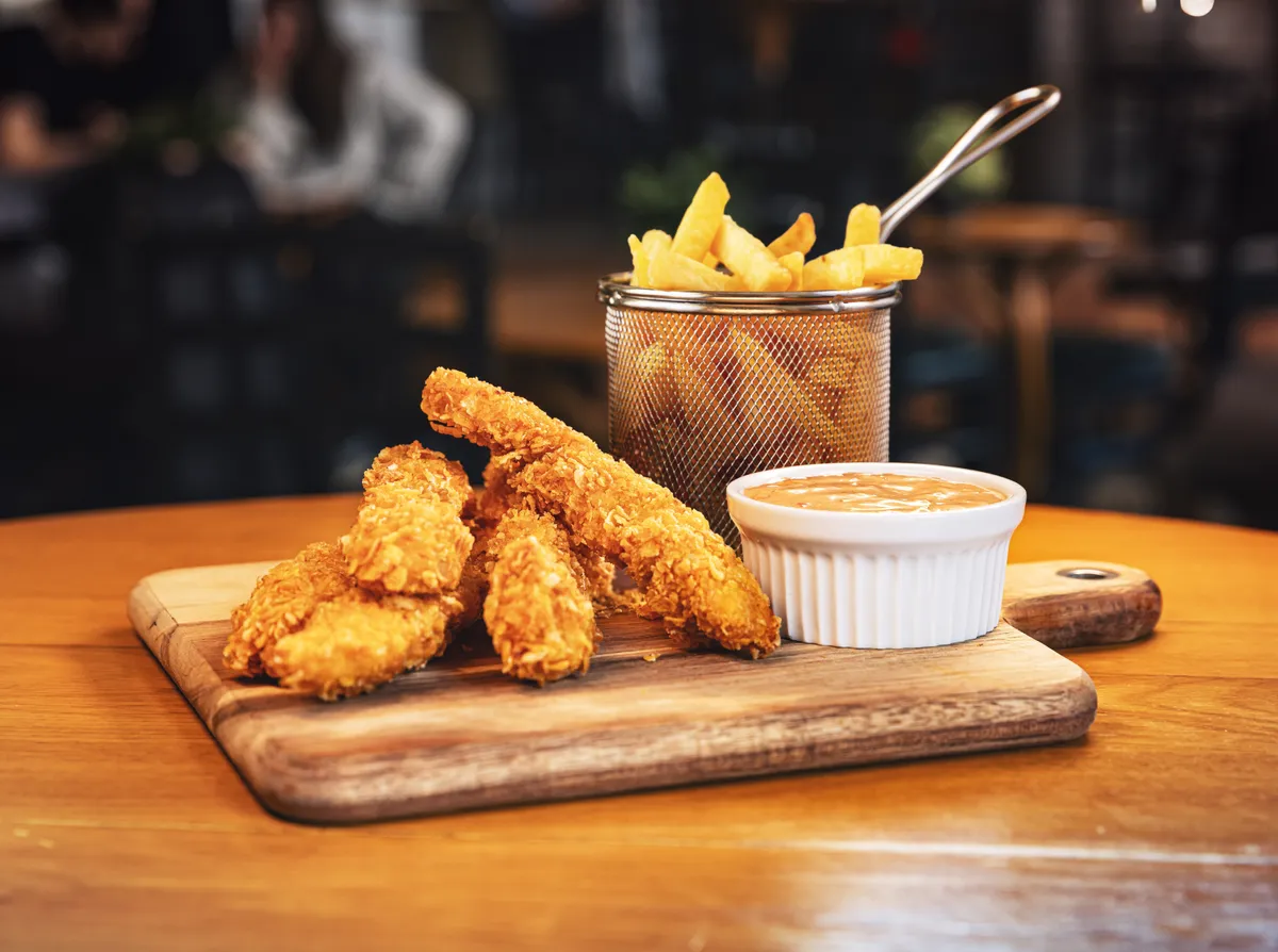 Ropogós csirkefalatok hasábburgonyával és mustáros mártogatóssal