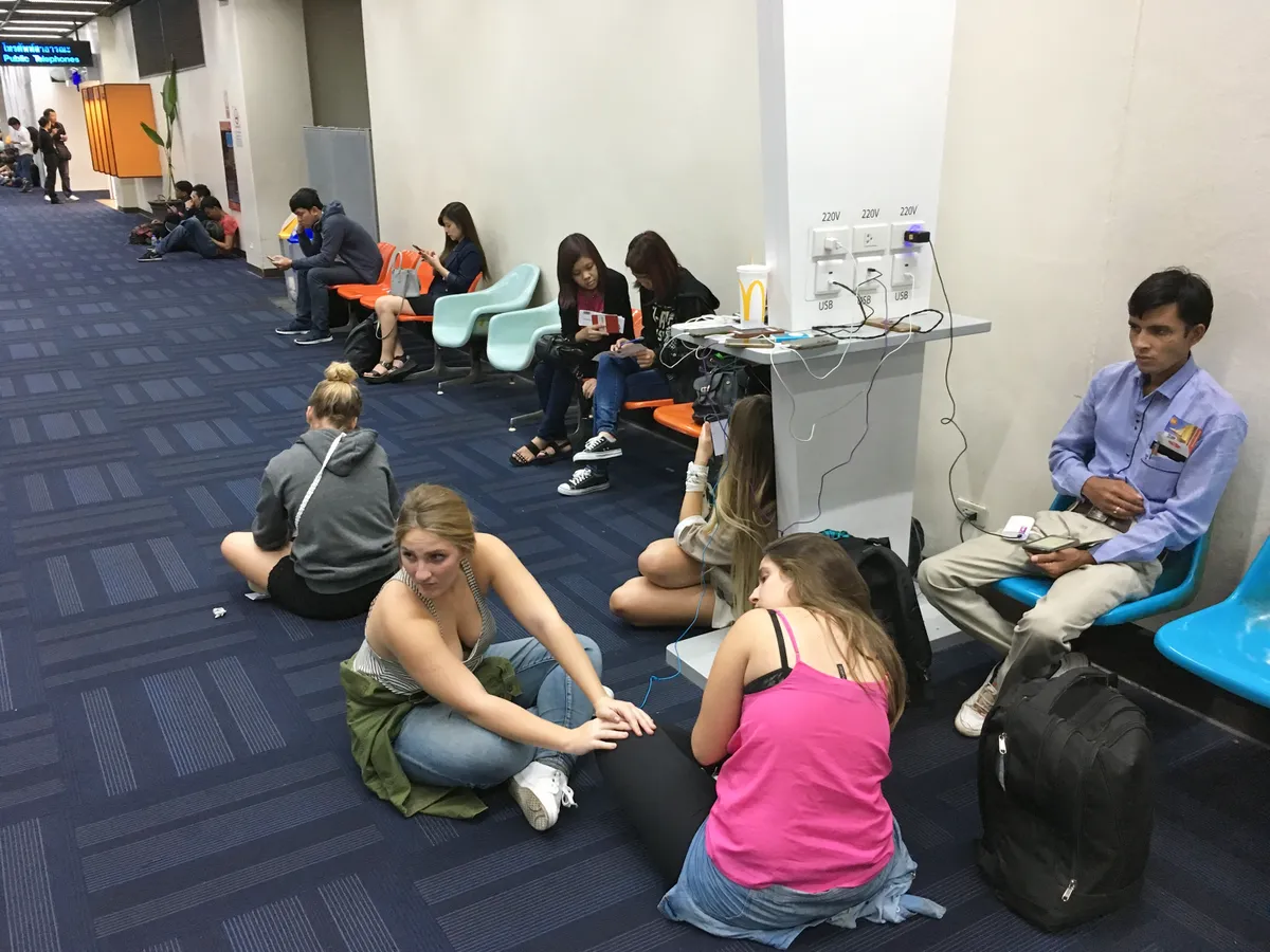Bangkok reptér, turisták tölti a telefonjaikat