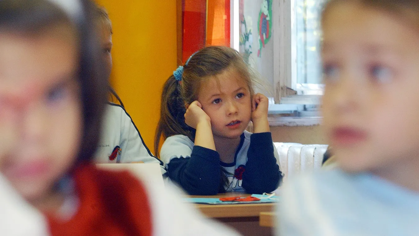 Copfos kislány az iskolapadban iskolakezdéskor