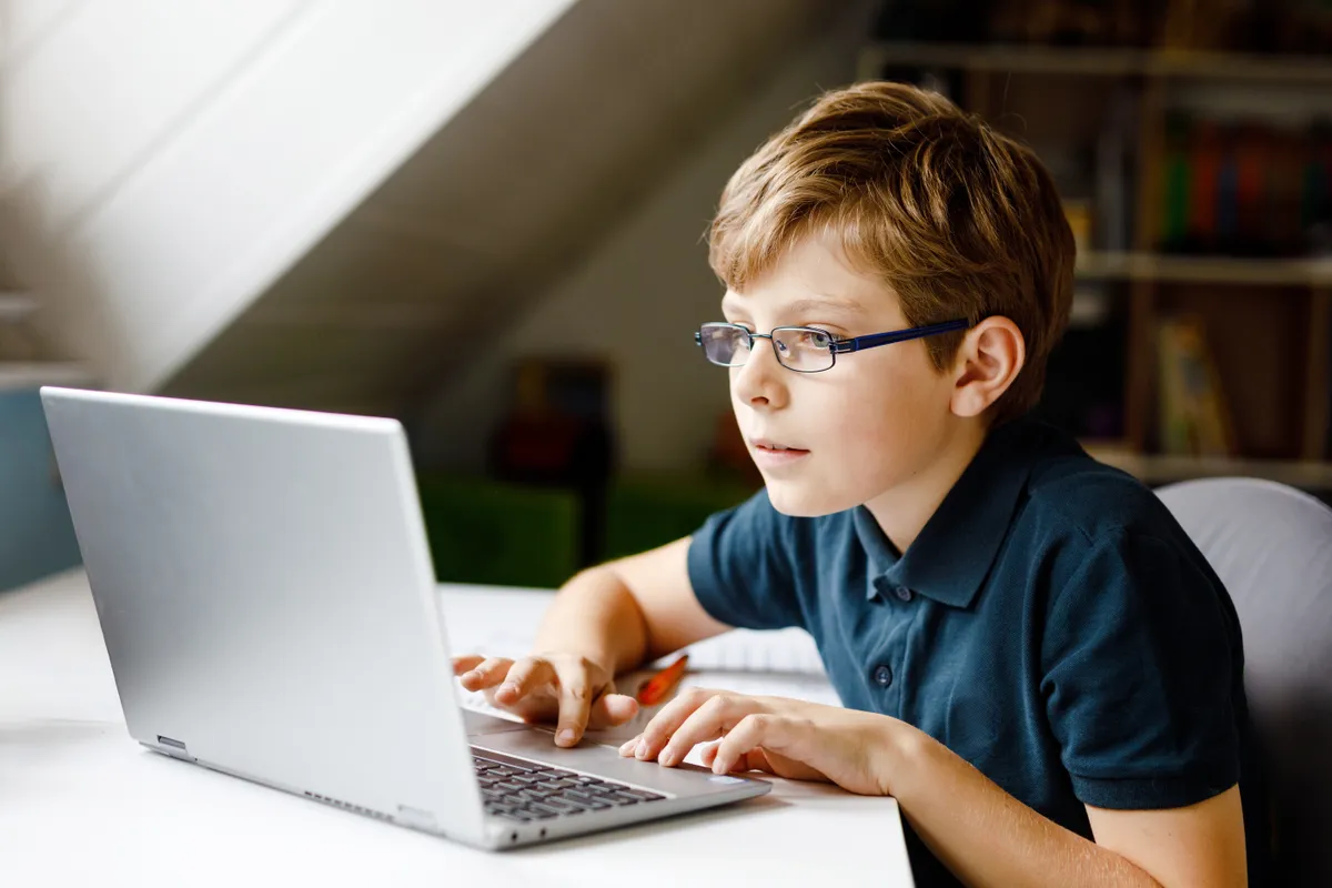 laptop gyerekeknek, alsó tagozatos kisfiú használ laptopot tanuláshoz