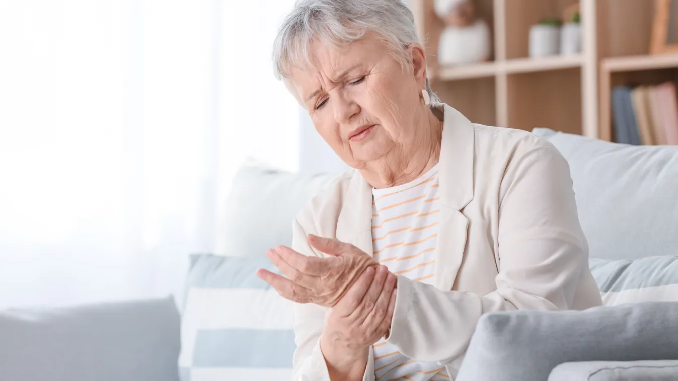 Idős nő ízületi gyulladás okozta fájdalom miatt a csuklóját szorítja