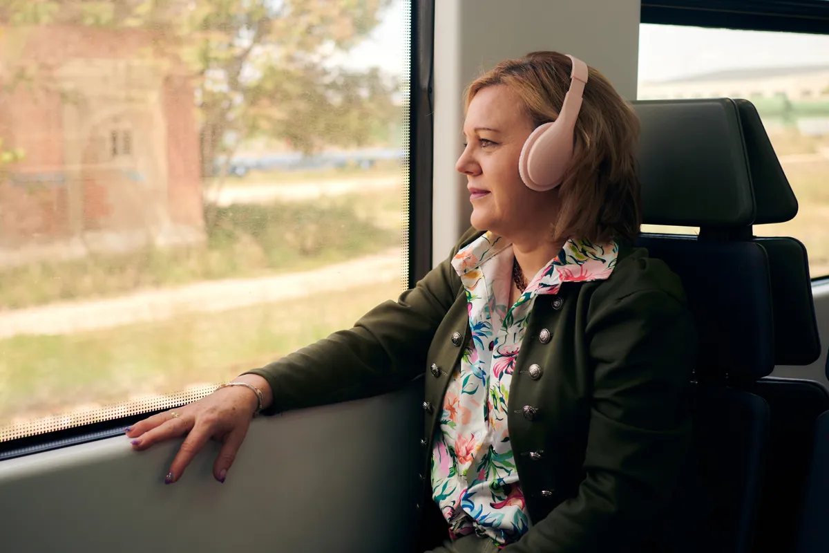 Utazási hányinger miatt a buszon zenét hallgató nő