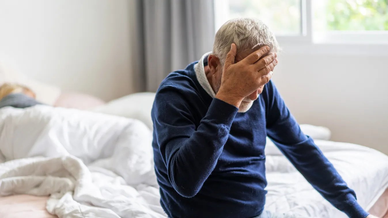 Egy idős férfi kék pulcsiban, Alzheimer-kórban szenved.
