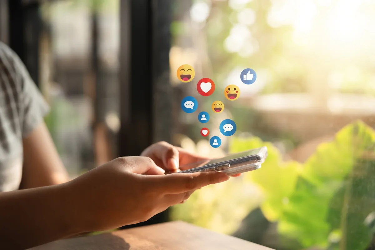 Egy fiú a telefonján használja a közösségi média oldalakat, ami akár az ADHD-val is összefügghet. 