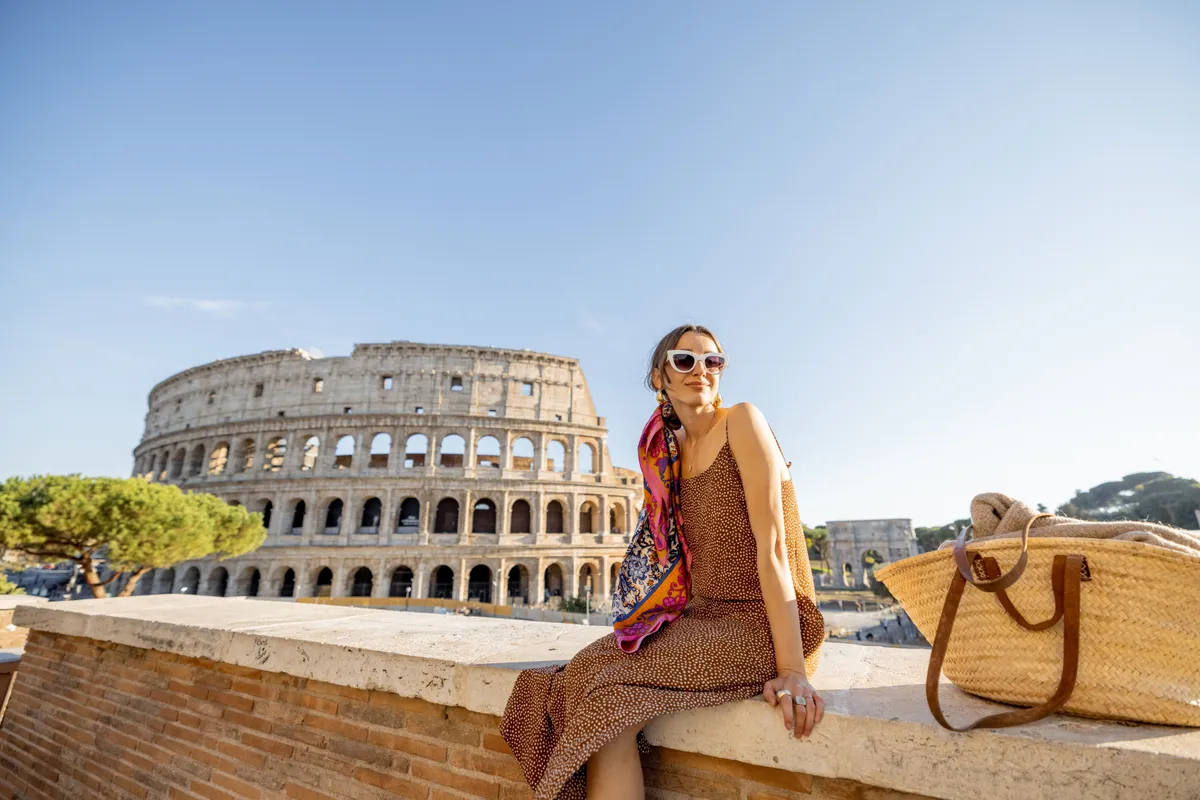 Olaszország-kvíz, fiatal nő napszemüvegben, táskával a Colosseum előtt