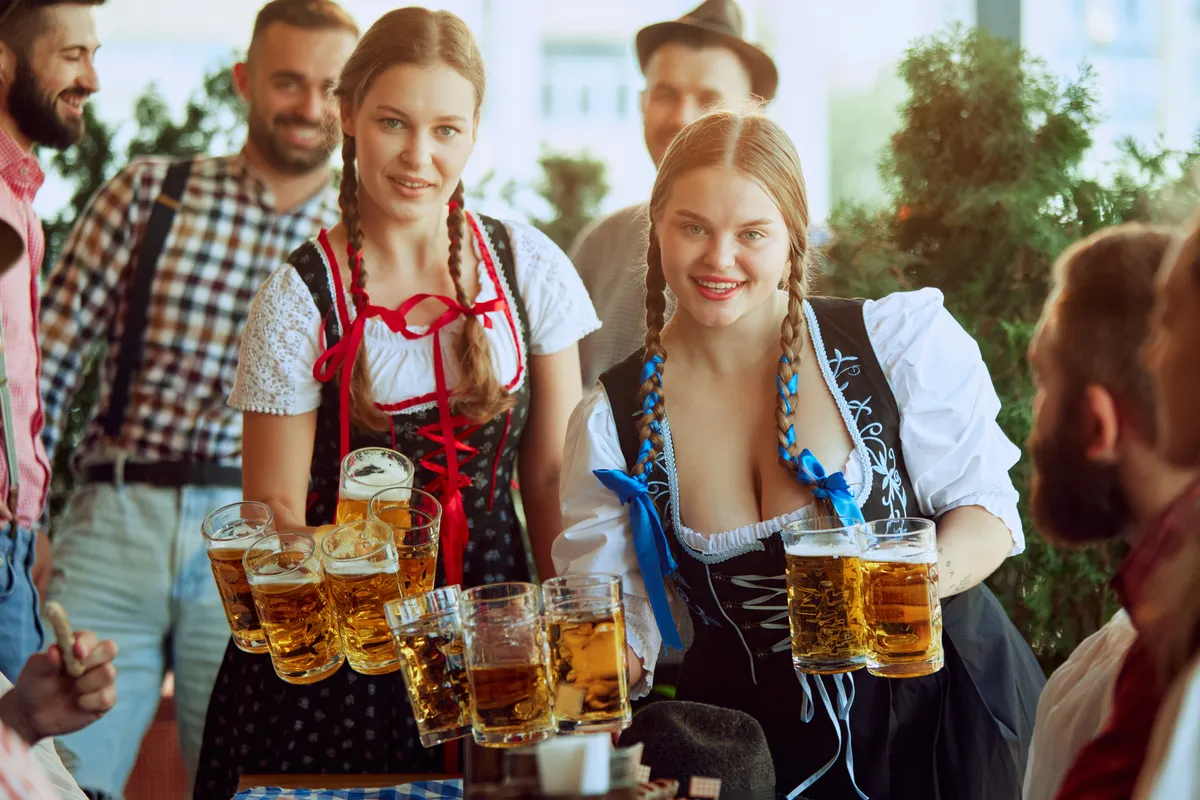 fiatal nők söröskancsókkal az Oktoberfesten, Münchenben
