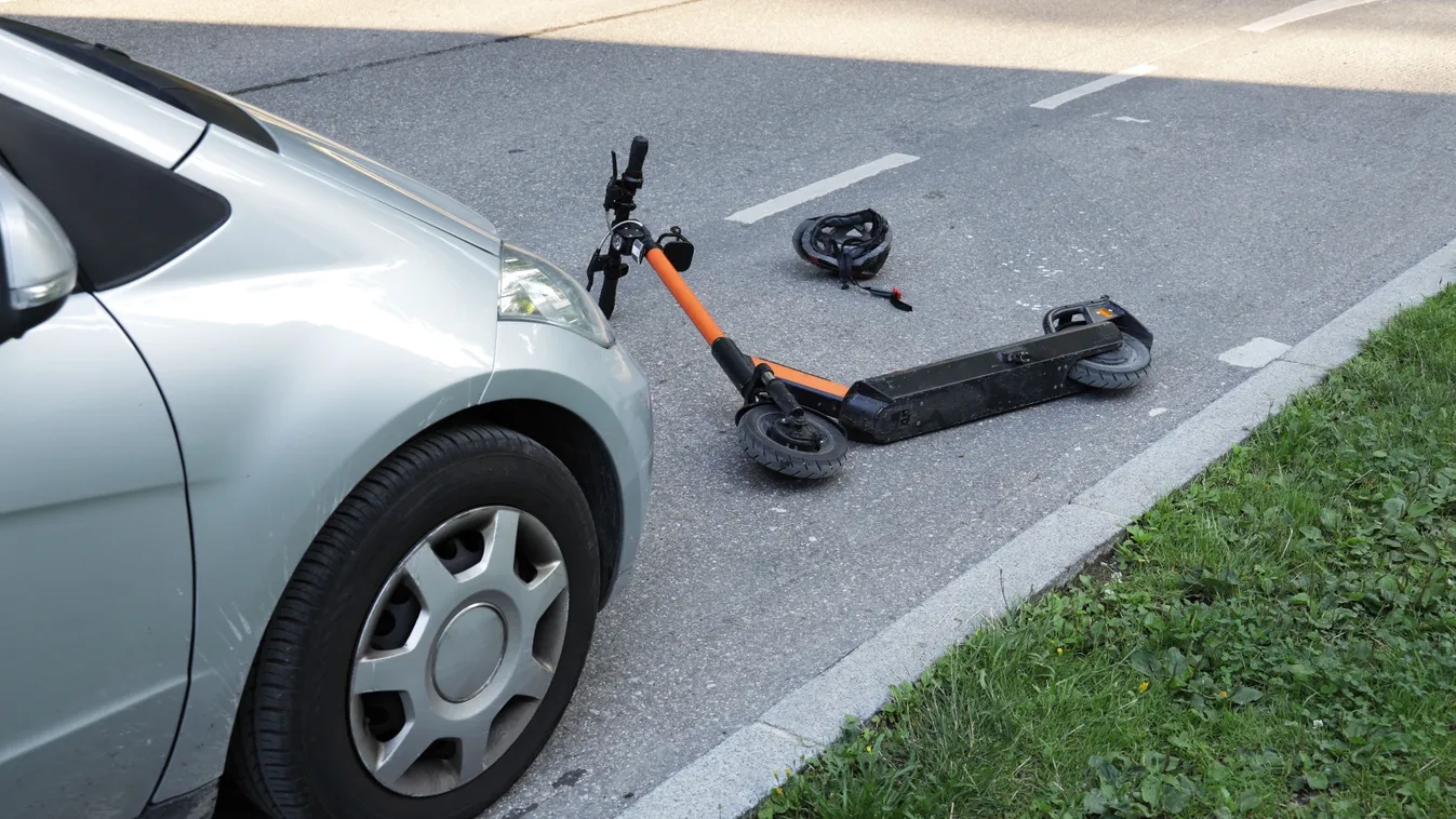 Elektromos rolleres baleset helyszíne eldőlt rollerrel és megállt autóval